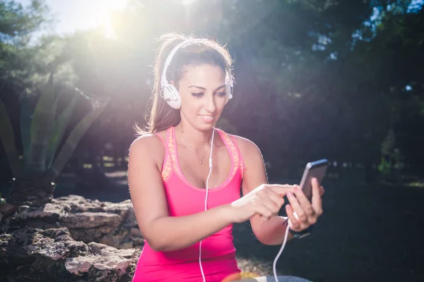 Athletic woman before start running setting up her smart phone app, fitness concept