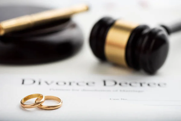 Divorce decree, gavel and wedding rings. Selective focus