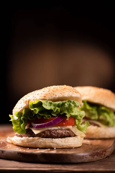 Sabrosa hamburguesa a la parrilla con lechuga, queso y cebolla servida — Foto de Stock