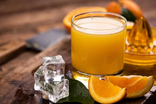 Vidro de suco de laranja na mesa de madeira — Fotografia de Stock