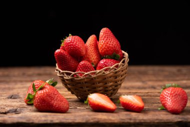 Eski ahşap masada bir sepet çilek