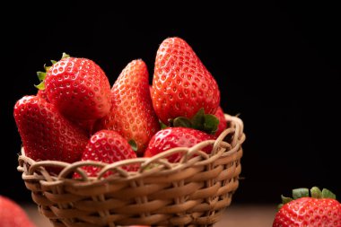 Eski ahşap masada bir sepet çilek