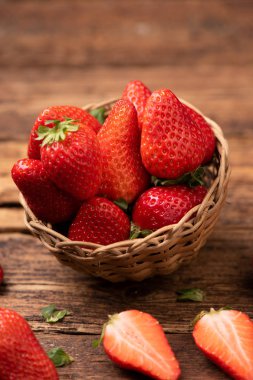 Eski ahşap masada bir sepet çilek