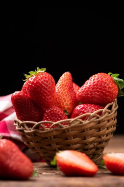 Eski ahşap masada bir sepet çilek