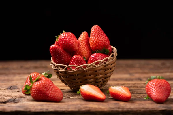 Eski ahşap masada bir sepet çilek