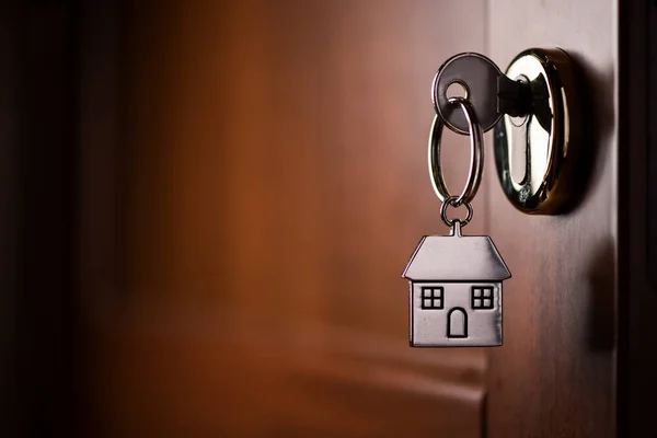 La llave de la casa en la puerta. Símbolo, cromo — Foto de Stock