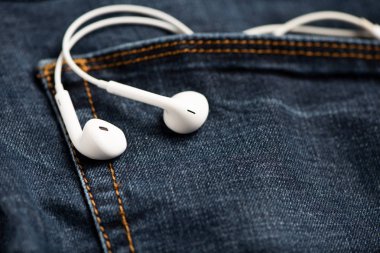 Mavi kot pantolon ve beyaz kulaklık ön cebinde Smartphone