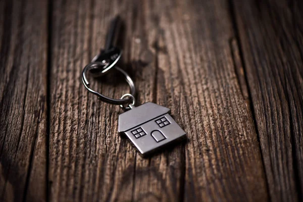 Dům key ring a staré dřevěné pozadí — Stock fotografie