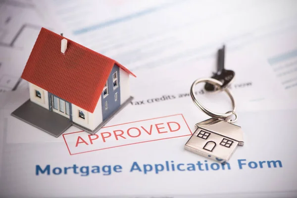 Un formulario de solicitud de préstamo hipotecario aprobado con llave de la casa y r — Foto de Stock