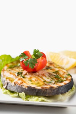 Beyaz tabakta salata ve limon ile ızgara kelime balığı 