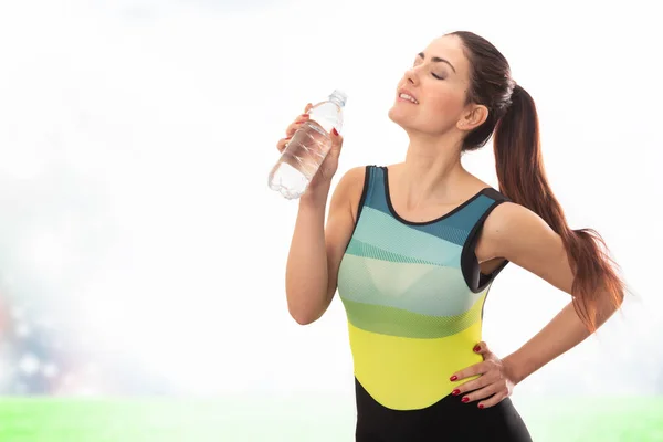 Beautiful young sports lady drinking water — Stock Photo, Image