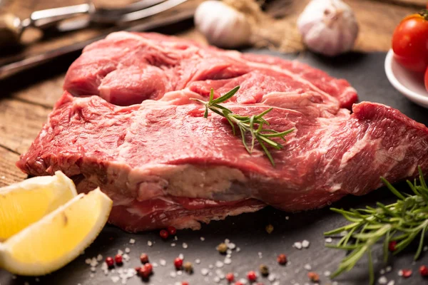 Carne fresca cruda en una tabla de cortar negra — Foto de Stock