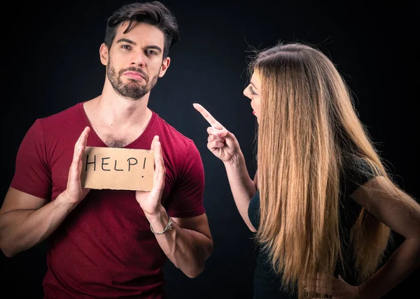 young couple with HELP sign isolated on dark background