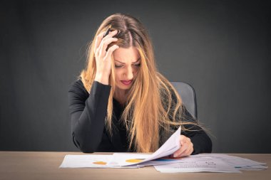 Ofisteki izole kâğıt işleri yüzünden strese giren sarışın bir kadın.