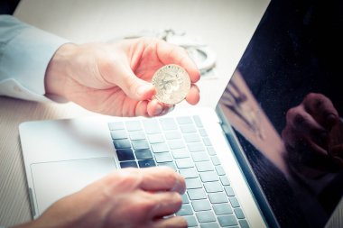 Ofis masasındaki Bitcoin 'e dikkatlice bakan bir adama yaklaş.