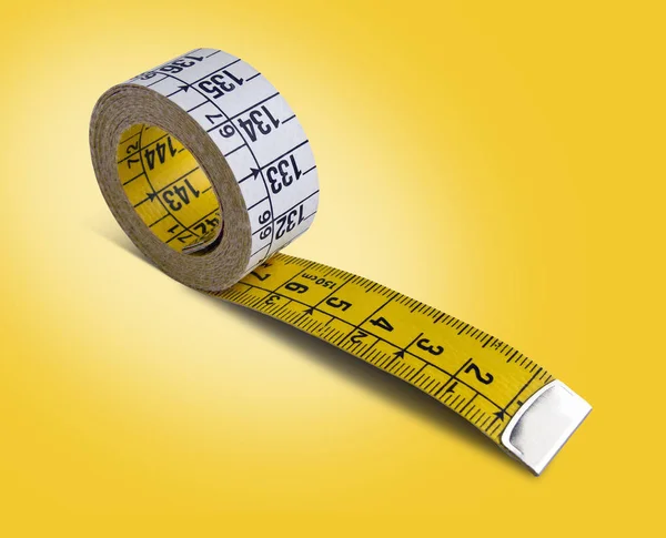 黄色の背景に分離された黄色の白い測定テープ — ストック写真