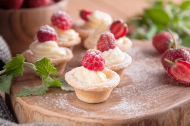 Tartlets krem, ahududu, çilek ile.