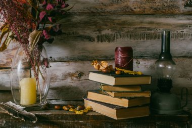 kuru yaprakları bir vazo içinde. Vintage iç. kitap, mum ve oli lamba masanın üzerinde. ahşap background.autumn