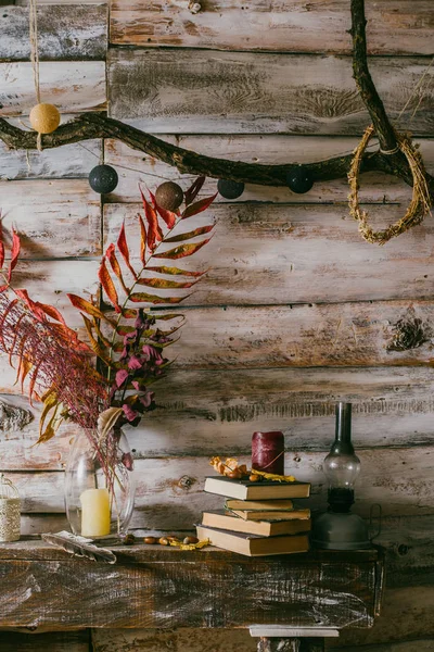 kuru yaprakları bir vazo içinde. Vintage iç. kitap, mum ve oli lamba masanın üzerinde. ahşap background.autumn
