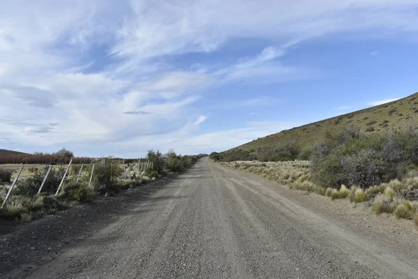 Gravel road in the countryside among blue sky at afternoon