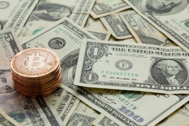 Dolar banknotları üzerine yığılmış Bitcoin paraları.