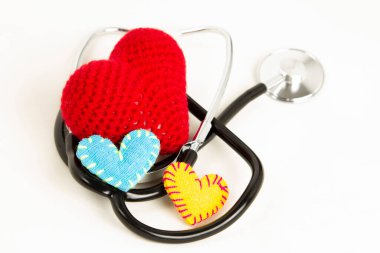 Heart health and prevention concept. Stethoscope and red heart of crochet on white isolated background with space for text.  clipart