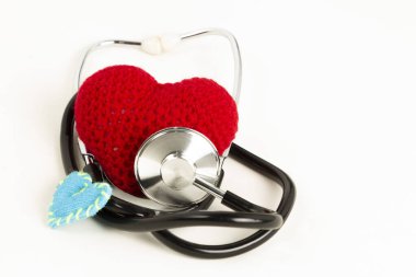 Heart health and prevention concept. Stethoscope and red heart of crochet on white isolated background with space for text.  clipart