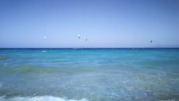 ロードス島のギリシャの多くの人々 は海岸のギリシャ ロードス島練習カイト サーフィン風と太陽の光によって波を楽しんで — ストック動画