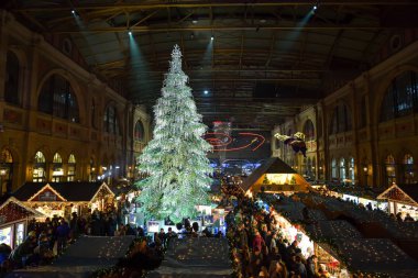 Zürih, İsviçre - 15 Aralık 2018: insanlar geleneksel Noel pazar ziyaret Zürih Ana Tren İstasyonu İsviçre. Pazar uzun Noel ağacı süslü Swarovski tarafından hakimdir.