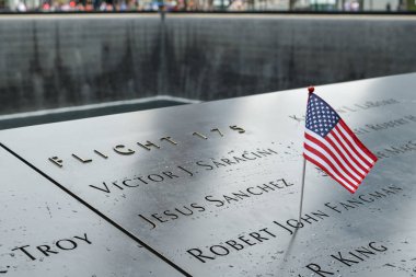 New York City, USA - October 4, 2018: Small american flag on 9/11 memorial in Lower Manhattan, New York City during October 2018 clipart