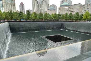 New York City, USA - October 4, 2018: People walking around one of the 9/11 memorial pools in New York City, USA in October 2018 clipart