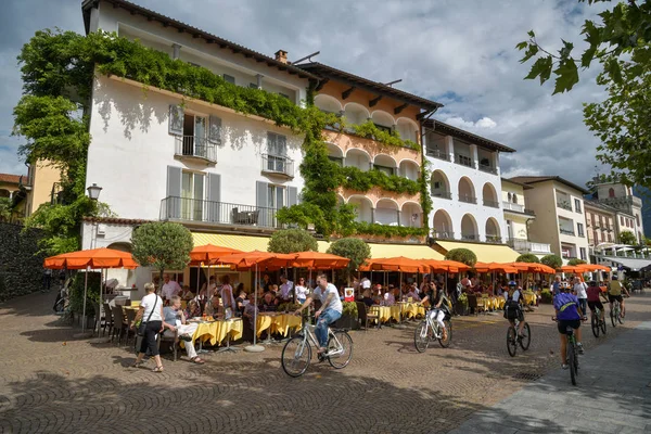 Cyclists driving next to open restaurant on the promenade in Asc