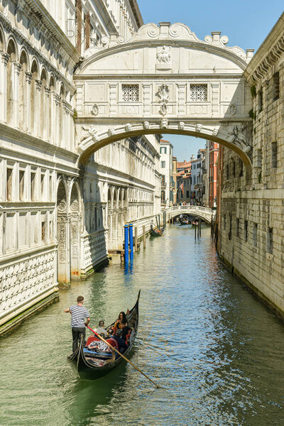 Gondola riding under Bridge of Sighs close to San Marco Square i