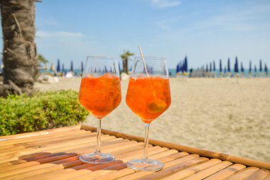 Lido sahilde ahşap masada duran Aperol iki bardak,