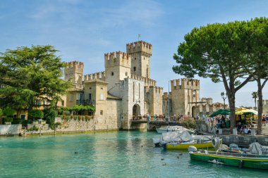 Sirmione, İtalya - 19 Temmuz 2019: İtalya 'nın Sirmione kentindeki güzel şatonun önünde yazın keyfini çıkaran turistler