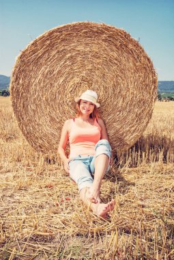 Saman yığını ile poz genç gülümseyen beyaz kadın. Ülke kavramı. Kırmızı Fotoğraf Filtresi.