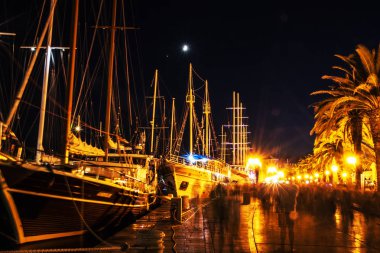 Trogir, Hırvatistan - 28 Temmuz 2017: tam turist ve Yelkenli tekneler limanda, Trogir, Hırvatistan gezi. Gece sahne. Yaz tatili. Seyahat hedef.