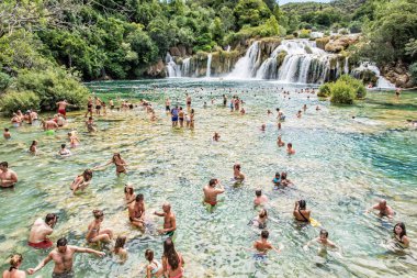Trogir, Hırvatistan - 27 Temmuz 2017: Çok sayıda turistin şelaleler, Krka, Hırvatistan, Milli Parkı içinde yüzüyor. Yaz tatili. Seyahat hedef. Açıklayıcı yazı işleri.