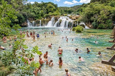 Trogir, Hırvatistan - 27 Temmuz 2017: Çok sayıda turistin şelaleler, Krka, Hırvatistan, ulusal doğal park içinde yüzüyor. Yaz tatili. Seyahat hedef. Açıklayıcı yazı işleri.
