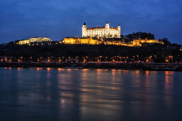 Castle and house of parliament is mirroring in Danube river, Slovak republic. Night panoramic photo. Travel destination.