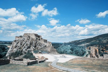 Devin yakınındaki Bratislava, Slovakya Cumhuriyeti, Orta Avrupa'da ünlü Kalesi. Bulutlu gökyüzü ve çevresindeki peyzaj. Deniz mavisi ve turuncu filtre fotoğraf.