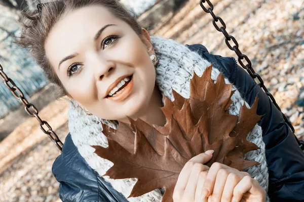 Adolescente souriante avec des feuilles de chêne brun dans les mains — Photo