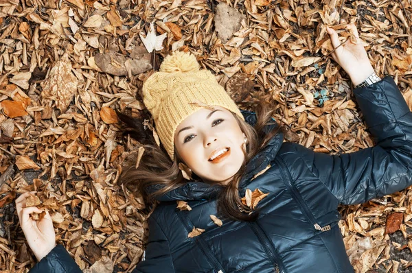 Giovane ragazza adolescente sdraiata in foglie di autunno — Foto Stock