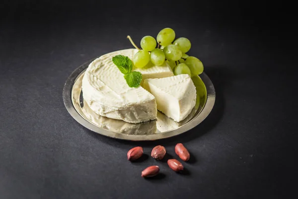 Camembert auf dem Teller mit Trauben, Erdnüssen und Minze — Stockfoto