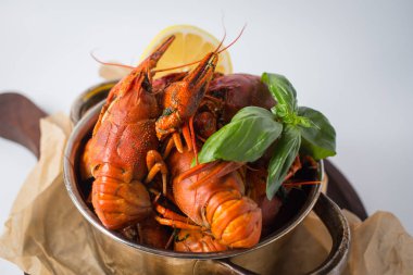 Kazan haşlanmış crawfishes, yeşil ve limon ile Kraft kağıt ile Paketli