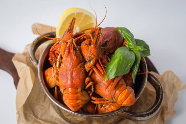 Kazan haşlanmış crawfishes, yeşil ve limon ile Kraft kağıt ile Paketli