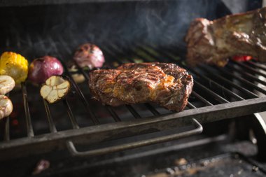 Sarımsak, soğan, Mısır, domates ve duman ile sıcak kömürlerin üzerinde ızgara et.