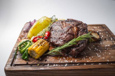 Aferin biftek ızgara Mısır, kırmızı biber, biber, soğan, sarımsak ve biberiye ahşap tahta üzerinde ile