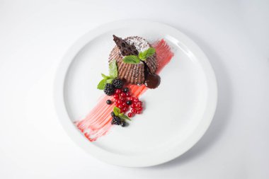 Çilek ve beyaz tabakta nane çikolatalı fondan.