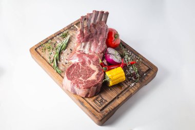 Kuzu, Mısır, soğan, biber biber, yeşil ve ahşap tahta üzerinde domates ham stenderloin.